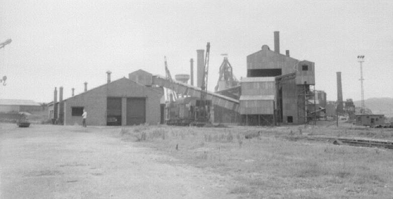 Millom ironworks, Cumbria, UK. Summer 1968. Ancillary buildings from west, with blast furnace array behind