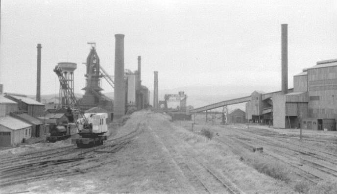 Millom ironworks, Cumbria, UK. Summer 1968. Looking through complex from west, with blast furnace at left, main building at right
