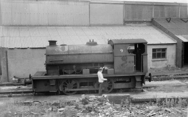 Millom ironworks, Cumbria, UK. Summer 1968. Saddle-tank steam locomotive No. 9 in front of ancillary building