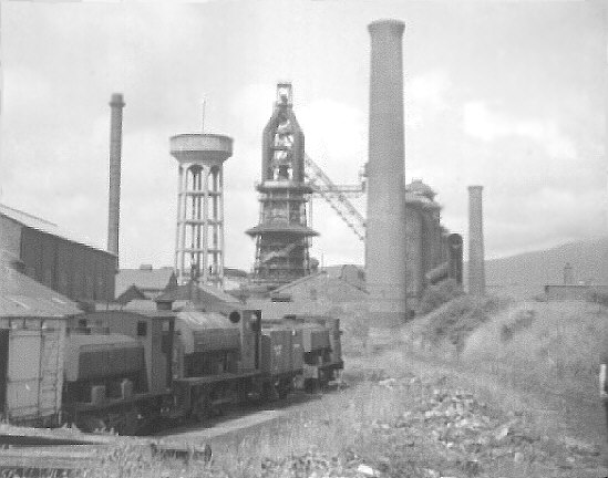 Millom ironworks, Cumbria, UK. Summer 1968. Blast furnace, water-tower, rail sidings etc. from west